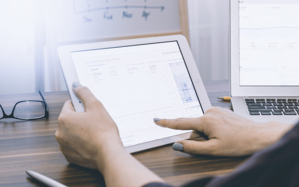 Business person analyzing Google Analytics on tablet